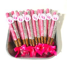 pink and silver candy sticks in a tin with bows on the top are for sale