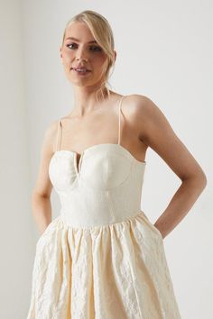 a woman in a white dress is posing for the camera with her hands on her hips