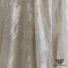 This lovely burnout silk is a metallic ivory color. Unique for the jacquard woven floral pattern applied with the burnout method to reveal a silk chiffon background, this burnout silk is a popular choice for a long evening dress, cocktail dress, sheer overlay, or scarf. This fabric is sheer, therefore a lining is needed if additional structure and modesty is desired. SKU: 6702 Content: Silk/Lurex Blend Color: Metallic Ivory Width: 43 inches Origin: Imported Elegant White Fabric For Festive Season, Elegant White Festive Fabric, Festive Cream Elegant Fabric, Elegant White Fabric For Spring, Elegant White Spring Fabric, Cream Silk Fabric For Wedding, Burnout Fabric, Orange Chiffon, Long Evening Dress