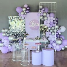 purple and silver balloons are on display in front of a backdrop with the word sara