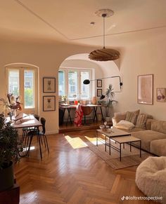 a living room filled with lots of furniture and decor on top of hard wood flooring