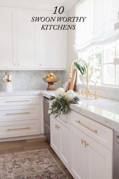 a kitchen with white cabinets and marble counter tops, gold accents on the faucet