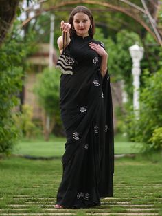 This is a three-piece black zebra saree set from the Ensembles collection. The black zebra saree is paired with a black sleeveless blouse. The blouse has front potli button opening, and a mandarin collar. There are beautiful zebra motifs of black and white bead work all over the saree. This saree set is crafted in pure organza fabric with contrast piping border. The outfit is completed with a heavily embellished, beadwork black and white zebra shape handbag. Designer Black Blouse Piece With Cutdana, Black Chanderi Handloom Blouse Piece, Black Saree Blouse Piece For Designer Wear, Black Blouse Piece For Saree Designer Wear, Black Chanderi Blouse Piece With Traditional Drape, Black Unstitched Traditional Blouse, Black Chanderi Saree Blouse Piece, Black Chanderi Blouse Piece, Black Saree Blouse For Designer Wear