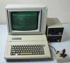 an old computer sitting on top of a table next to a small keyboard and mouse