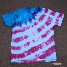 a red, white and blue tie - dyed t - shirt laying on the ground