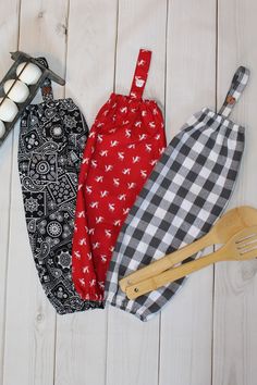 three oven mitts and two spatulas on a white wooden surface