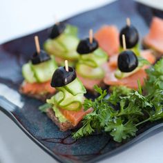 several appetizers are arranged on a plate with toothpicks and garnishes