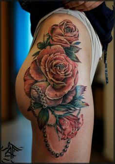 a woman's thigh with roses and pearls on it