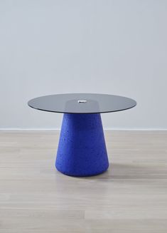 a blue table sitting on top of a hard wood floor next to a white wall