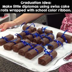 a table topped with lots of chocolate rolls covered in blue ribbon