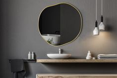 a bathroom with a sink, mirror and hanging lights on the wall next to it