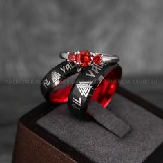 two wedding rings with roman numerals and red cubicles on top of each other