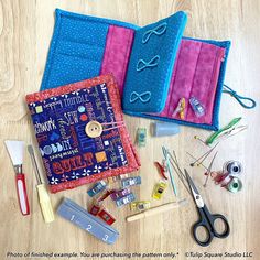 sewing supplies laid out on a wooden floor with scissors and other crafting items around them