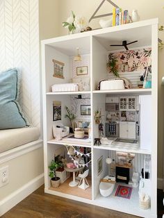 a doll house with lots of furniture and decor on it's shelves in a living room