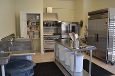 an industrial kitchen with stainless steel appliances and cleaning supplies