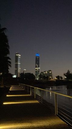 the city lights shine brightly in the night sky over water and boardwalks at dusk