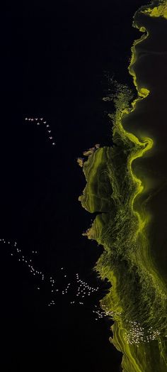 an aerial view of the water and land at night