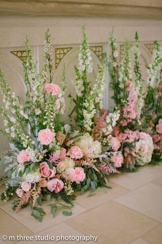 pink and white flowers are lined up on the floor