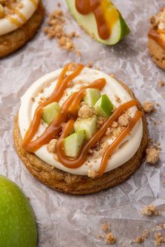 cookies with caramel, apples and whipped cream drizzled on them next to an apple