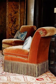 an orange chair sitting on top of a rug