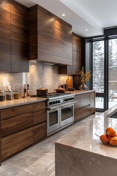 a modern kitchen with stainless steel appliances and wood cabinets, along with marble counter tops