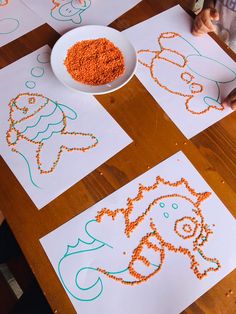 children's artwork is displayed on paper with orange beads