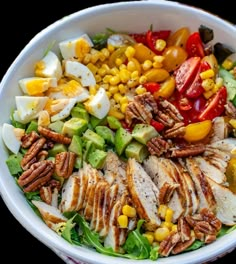 a salad with chicken, tomatoes, corn and dressing