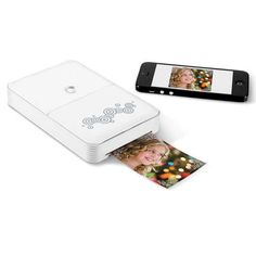 a polaroid printer with an iphone next to it and a photo on the screen