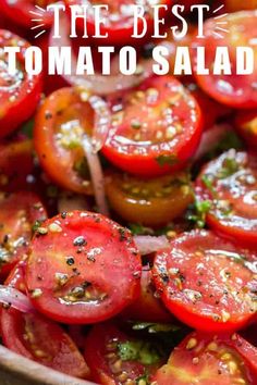 a wooden bowl filled with lots of sliced tomatoes and green stuff on top of it