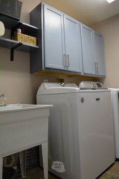 a washer and dryer sitting in a room next to each other with cabinets above them