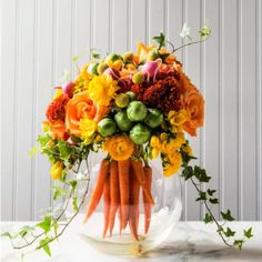 a vase filled with lots of flowers on top of a table