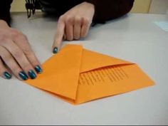 an orange envelope being folded on top of a table