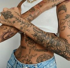 a woman with lots of tattoos on her arms and chest is posing for the camera