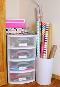 a white container filled with lots of different types of pens and paper on top of a wooden floor