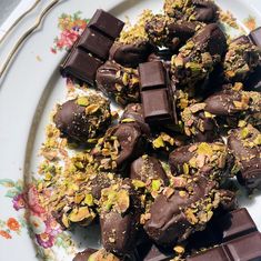 a plate full of chocolates and nuts on top of a floral design table cloth