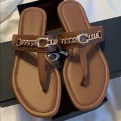 New Never Used Coach Sandals For Vacation With Round Toe, Coach Open Toe Sandals For Vacation, Coach Sandals For Vacation, Trendy Brown Sandals With Single Toe Strap, Brown Flat Flip Flops, Chic Brown Toe Post Sandals, Coach Brown Open Toe Sandals, Coach Closed Toe Beach Sandals, Trendy Coach Leather Sandals