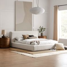 a bed with white sheets and pillows in a room