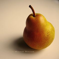 a single pear sitting on top of a white table