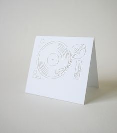 a white card with a drawing of a record player on it's front cover