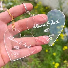 two heart shaped acrylic key chains held in someone's hand