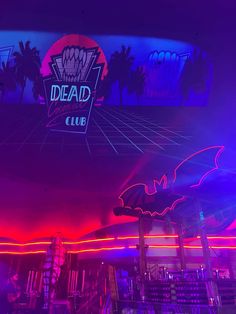 the neon sign for dead club is lit up in purple and blue colors with palm trees behind it