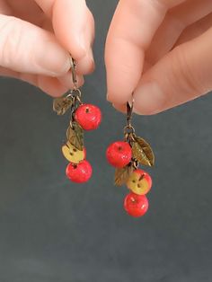 If you  If you're looking for a unique and unusual earrings, then you're in the right place! This delightful red Apple earrings would make a wonderful a lovely treat for friend, sister, girl, mom, and yourself!The  apple earrings features a realistic miniature red apple charm handcrafted using polymer clay.Each apple measures approx. 1 cm length These earrings are very lightweight and won't feel heavy on your earlobe, ensuring all-day comfort. The earring hooks are made from nickel-free and lead-free metal, making them safe and comfortable for sensitive ears.  size English earwires 16 *10 mm.  color: antique bronze  Check out other listings from my workshop. Thank you for your purchases! Fruit Collection  https://www.etsy.com/shop/miniwarsztat?ref=l2-about-shopname&from_page=listing§ion_id Red Novelty Drop Earrings, Cherry Colored Earrings For Valentine's Day Gift, Cherry Earrings For Valentine's Day Gift, Cherry Color Earrings For Valentine's Day Gift, Red Whimsical Nickel-free Earrings, Whimsical Red Nickel-free Earrings, Novelty Red Pierced Earrings, Novelty Red Earrings For Gift, Whimsical Red Drop Earrings