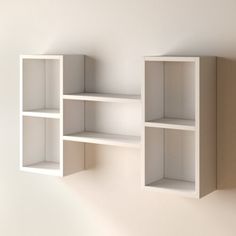 three white shelves on the wall with no one in them