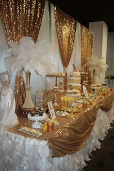 a table topped with lots of gold and white desserts on top of a table