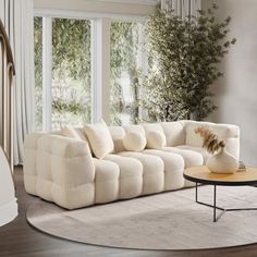 a living room filled with furniture and a white rug on top of a hard wood floor