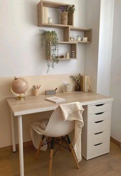 a white desk topped with a laptop computer next to a shelf filled with potted plants