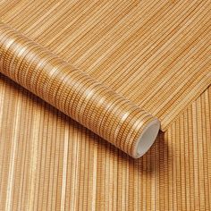 a roll of bamboo paper on top of a wooden flooring mat with the end rolled up