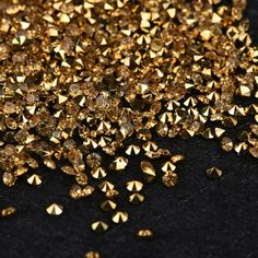 gold colored diamonds are scattered on a black surface