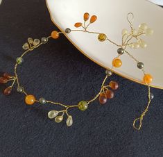 This 16 -inch fall hair vine is made on gold wire and is composed of yellow and burnt orange frosted teardrops, dragon vein round glass beads, orange quartzite and dark green Swarovski crystal pearls.  It has a rustic vibe and can be used for a Fall or Rustic wedding, home coming dance, or any other Autumn event where you want to add some interest to your hair. I can make it any length that you need, I can also add gold leaves if you want,  It can also be used as a necklace. You can attach a ribbon to the loops and then tie it around your neck. You might even wear it as a choker. Braid it into your hair, wear it as a wreath, halo or headband. Just give it to your hair stylist to work their magic.  I will place it in a plastic bag to help prevent tarnishing and then an adorable organza pouc Fall Wedding Hair, Yellow And Dark Green, Fall Wedding Hairstyles, Jewelry Bride, Wedding Hair Vine, Bridesmaid Flower, Beaded Hair, Hair Jewelry Wedding, Gold Leaves