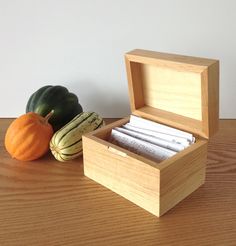 a wooden box filled with papers next to a pumpkin